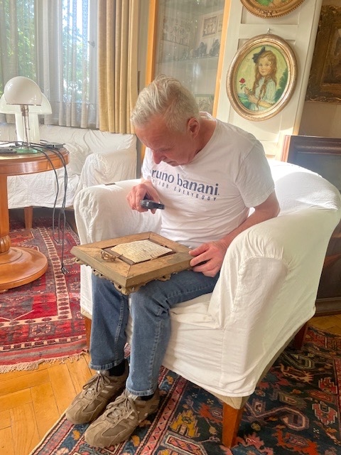 Hans Fritsch prüft Gemälde mit Lupe - Experte für Kunst und Wertgegenstände